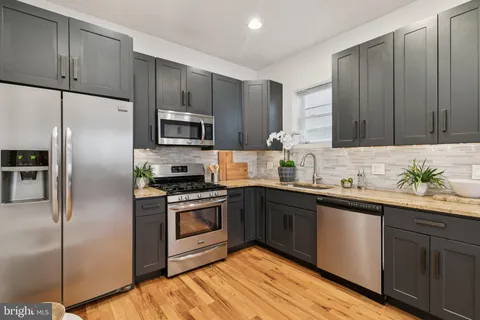 a kitchen with a sink a microwave a refrigerator and cabinets