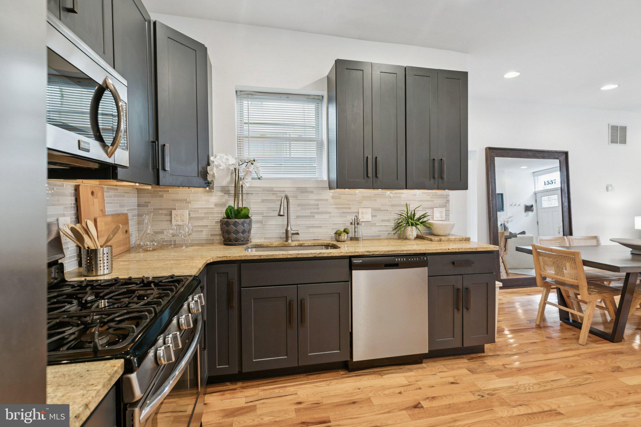 1537 Reed Street Philadelphia, PA 19146 - Photo 9 of 32 a kitchen with stainless steel appliances granite countertop a stove a sink dishwasher and cabinets with wooden floor