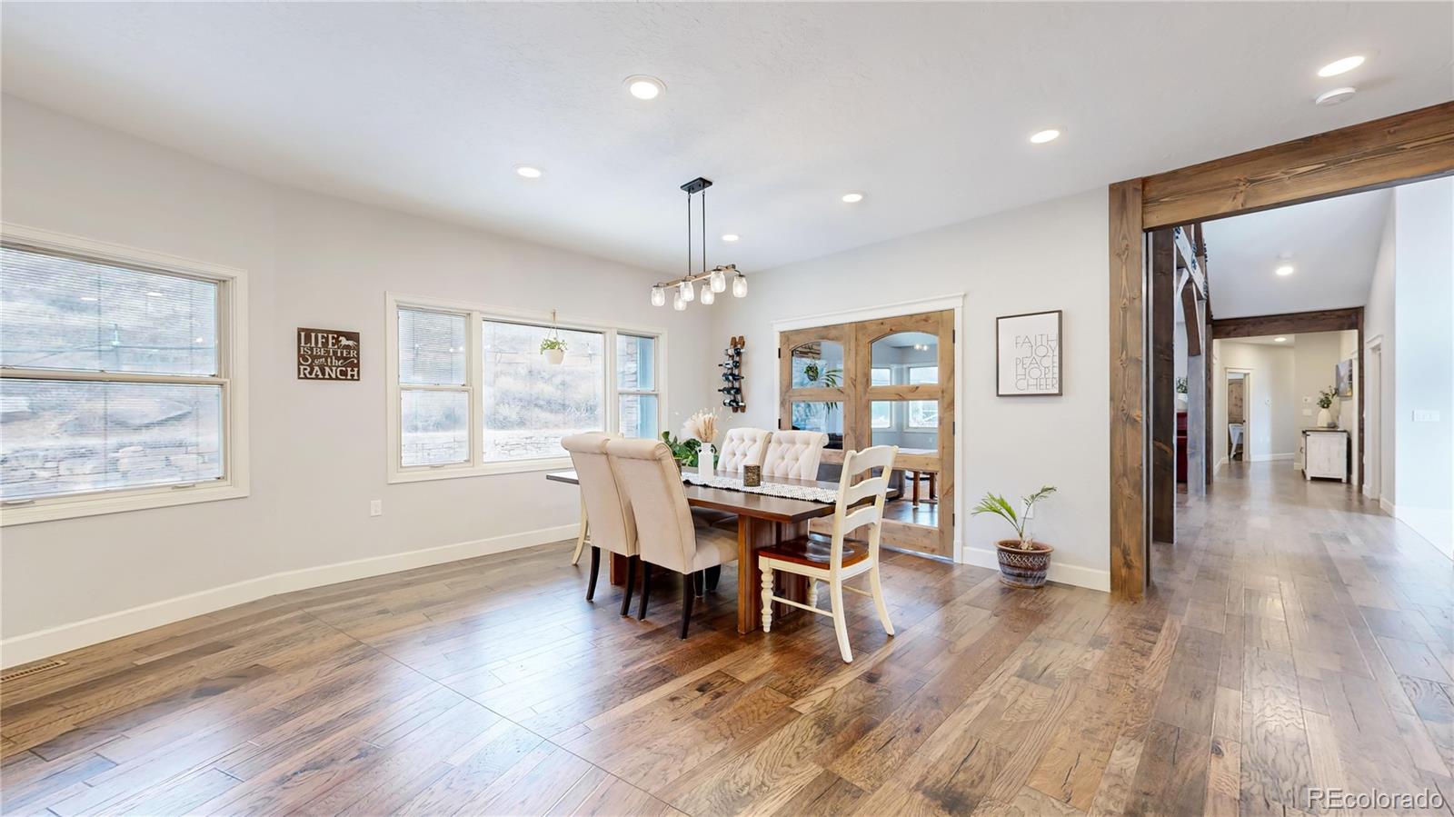 5575 Spring Glade Road Loveland, CO 80538 - Photo 11 of 49 a dining room with wooden floor a glass table and chairs