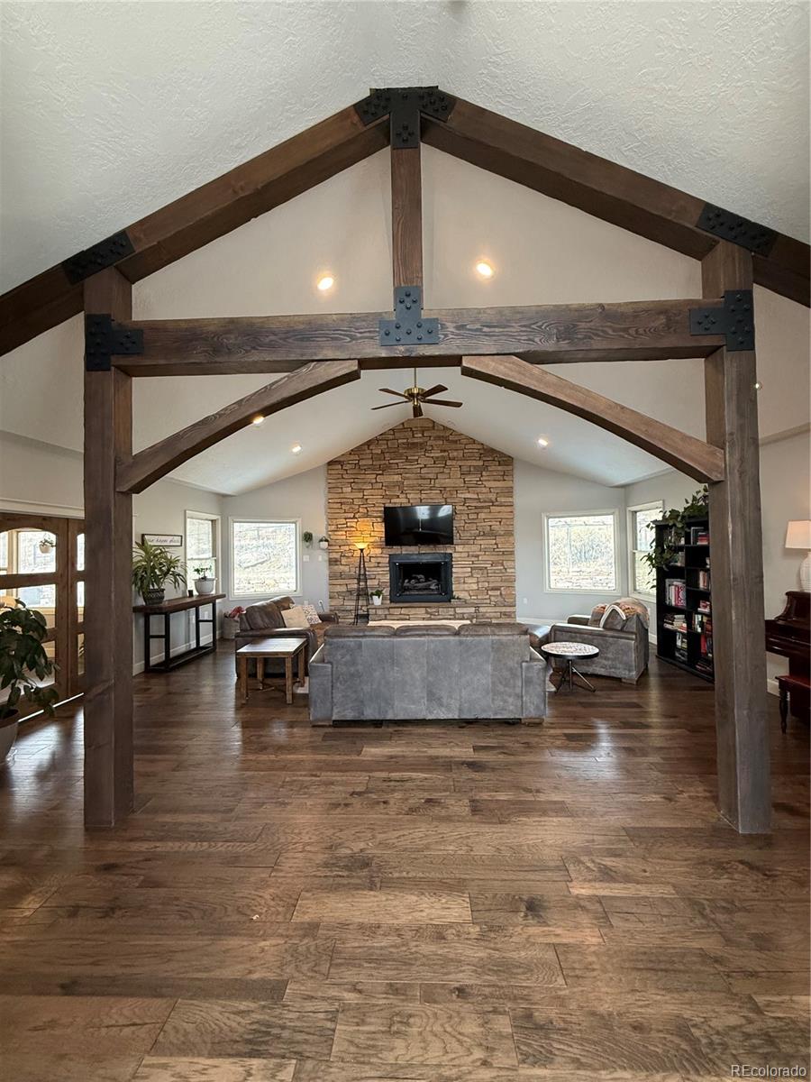 5575 Spring Glade Road Loveland, CO 80538 - Photo 12 of 49 a living room with fireplace furniture and a ceiling fan