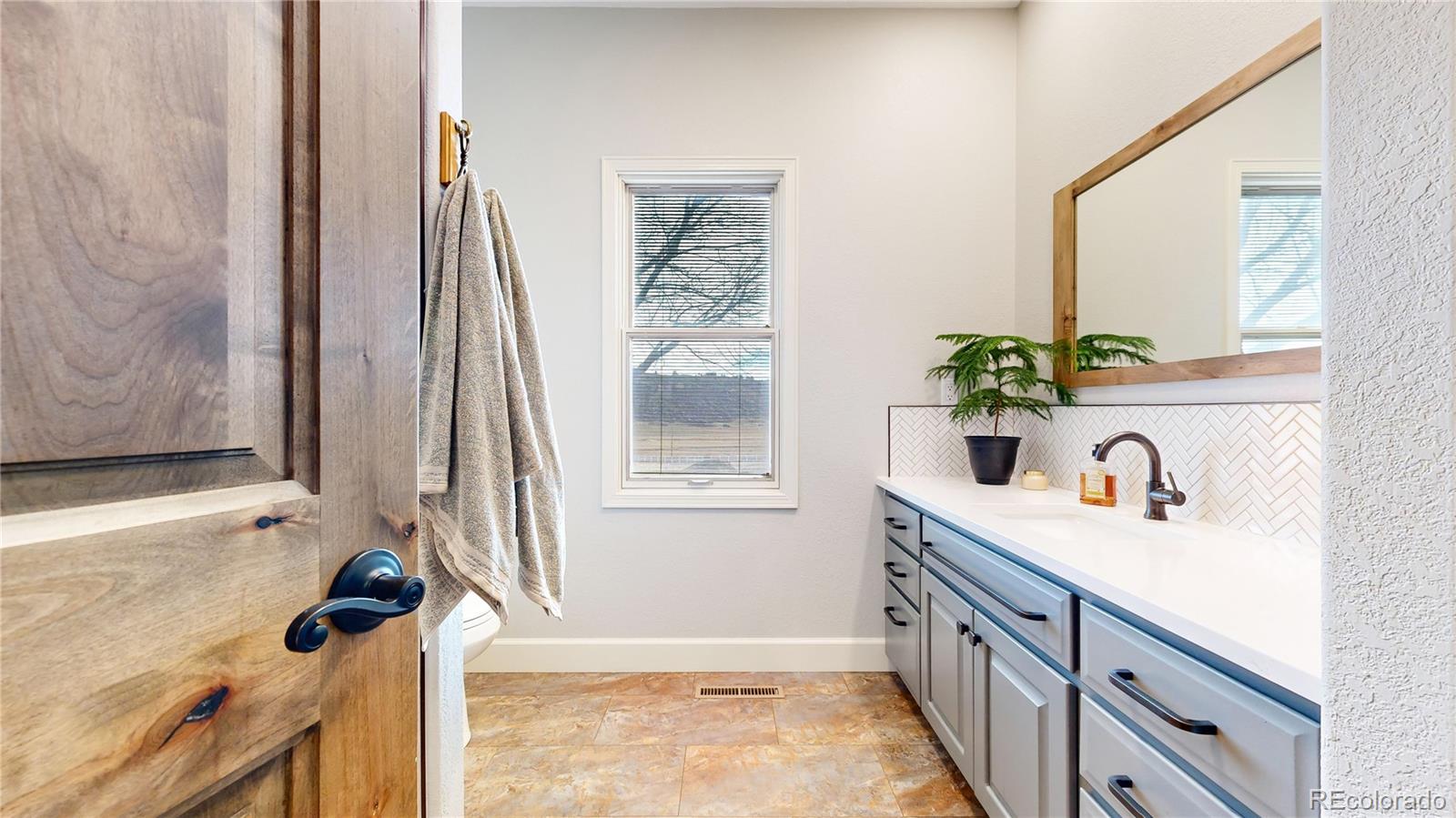 5575 Spring Glade Road Loveland, CO 80538 - Photo 27 of 49 a bathroom with a granite countertop sink a mirror and shower