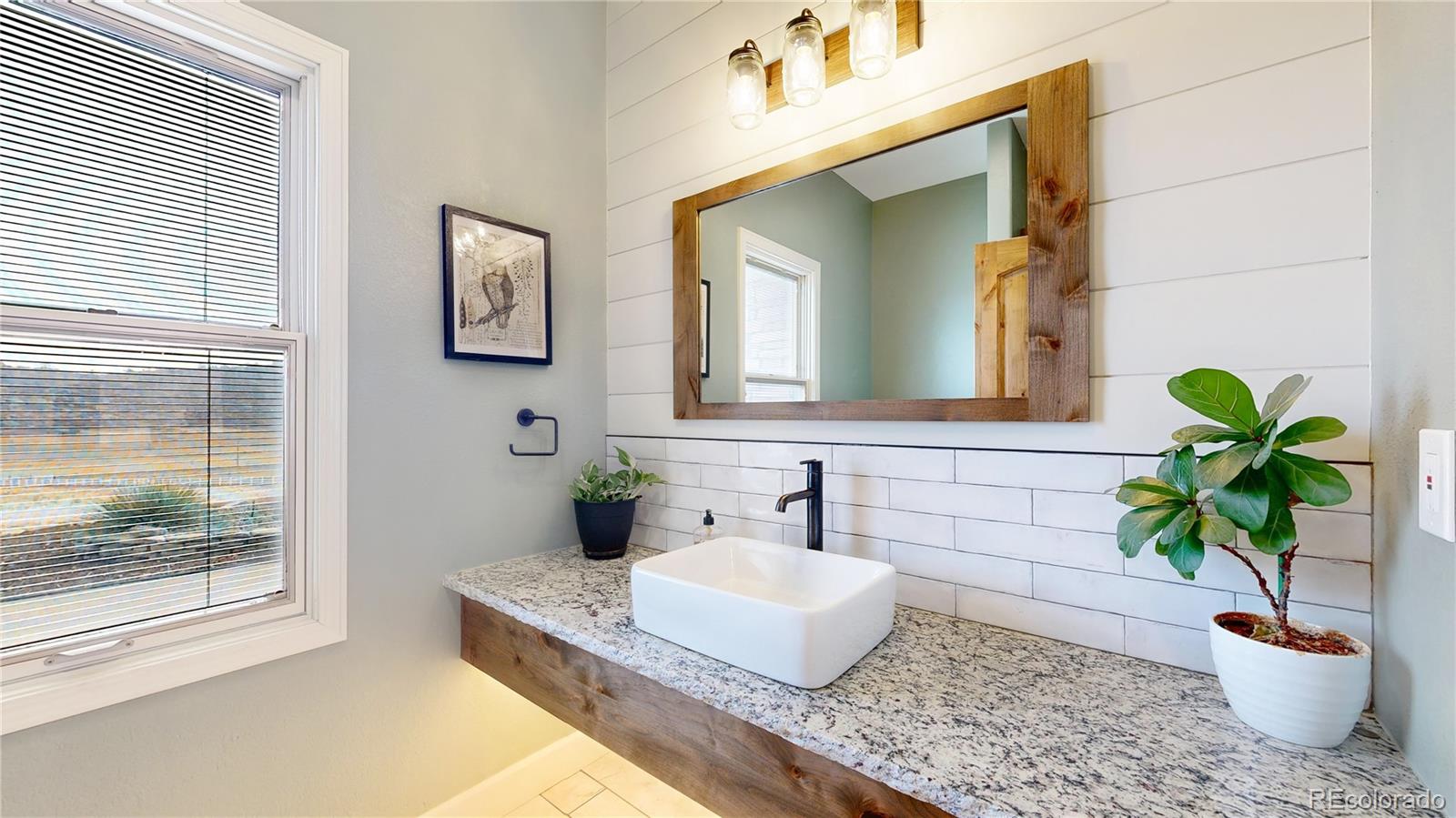 5575 Spring Glade Road Loveland, CO 80538 - Photo 28 of 49 a bathroom with a granite countertop sink a potted plant and a mirror