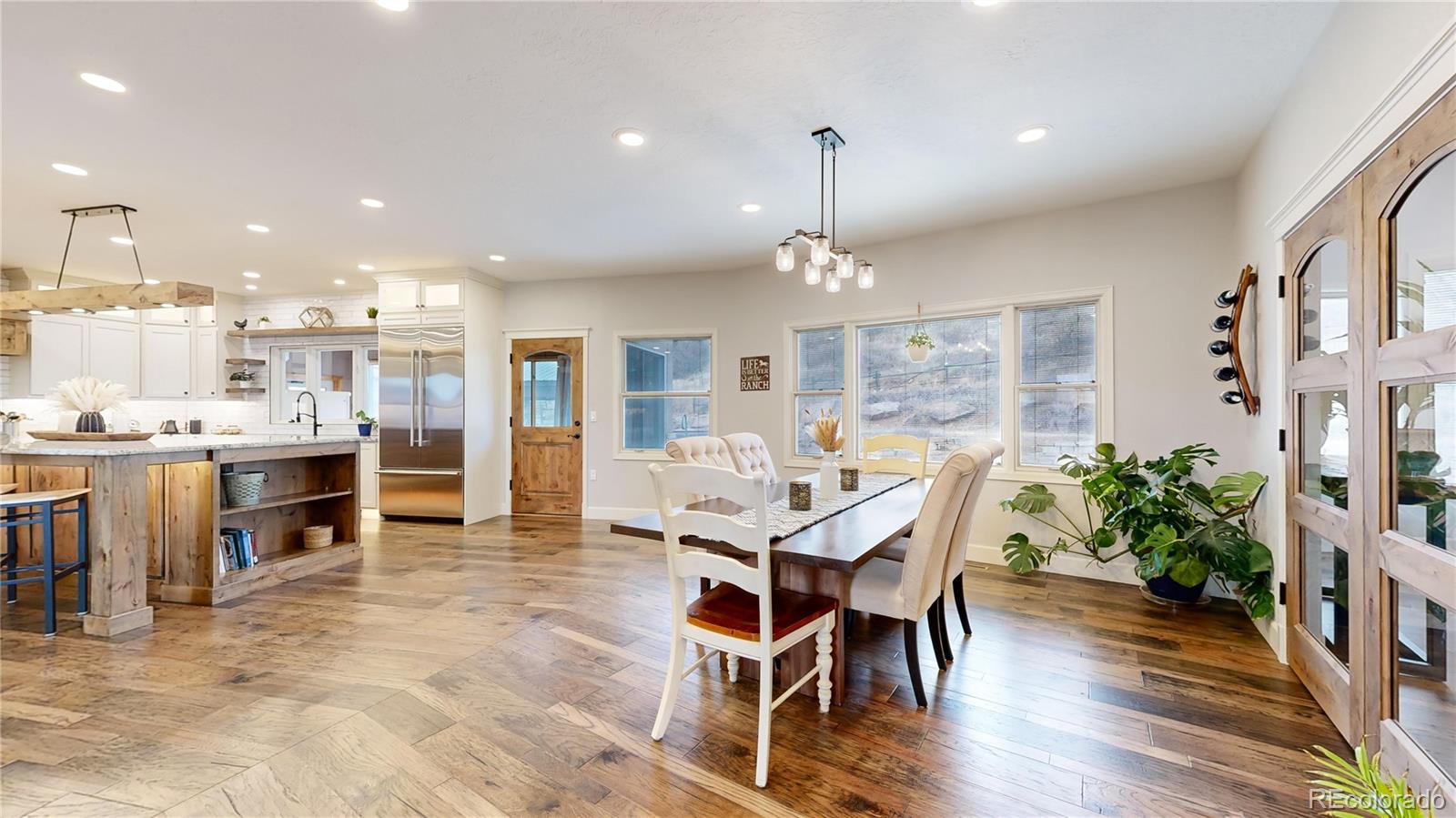 5575 Spring Glade Road Loveland, CO 80538 - Photo 9 of 49 a view of a dining room and livingroom with furniture wooden floor a chandelier