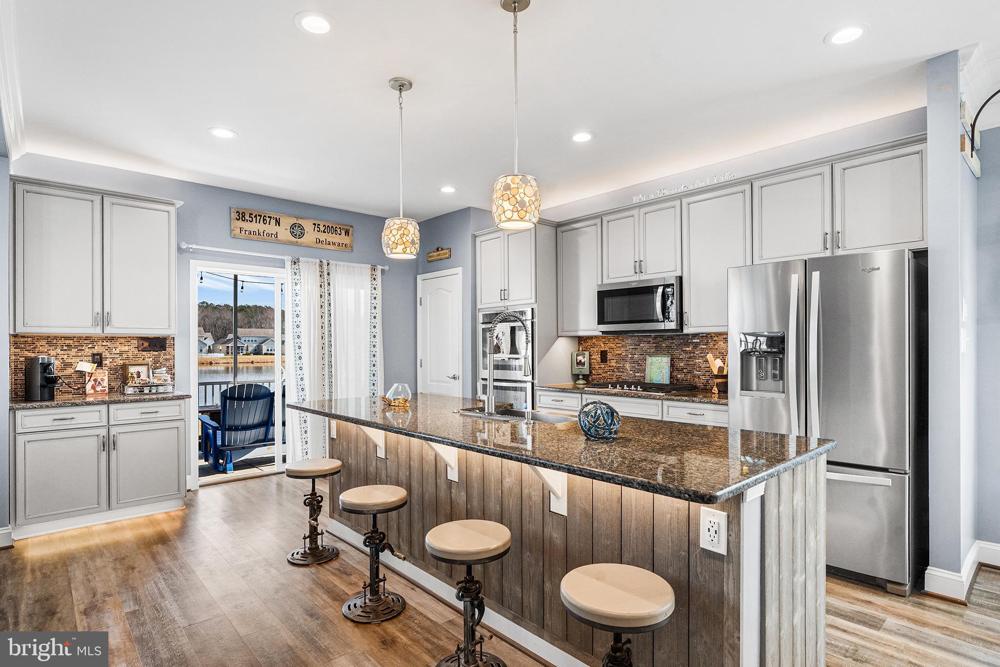 36207 Watch Hill Road Frankford, DE 19945 - Photo 8 of 35 a kitchen with a refrigerator a stove top oven a sink dishwasher and white cabinets with wooden floor