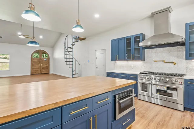 a kitchen with stainless steel appliances granite countertop a stove a sink and a refrigerator