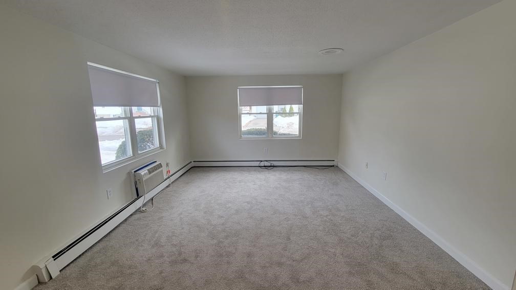 6 Whitman Road, Unit 6 Waltham, MA 02453 - Photo 2 of 12 an empty room with windows