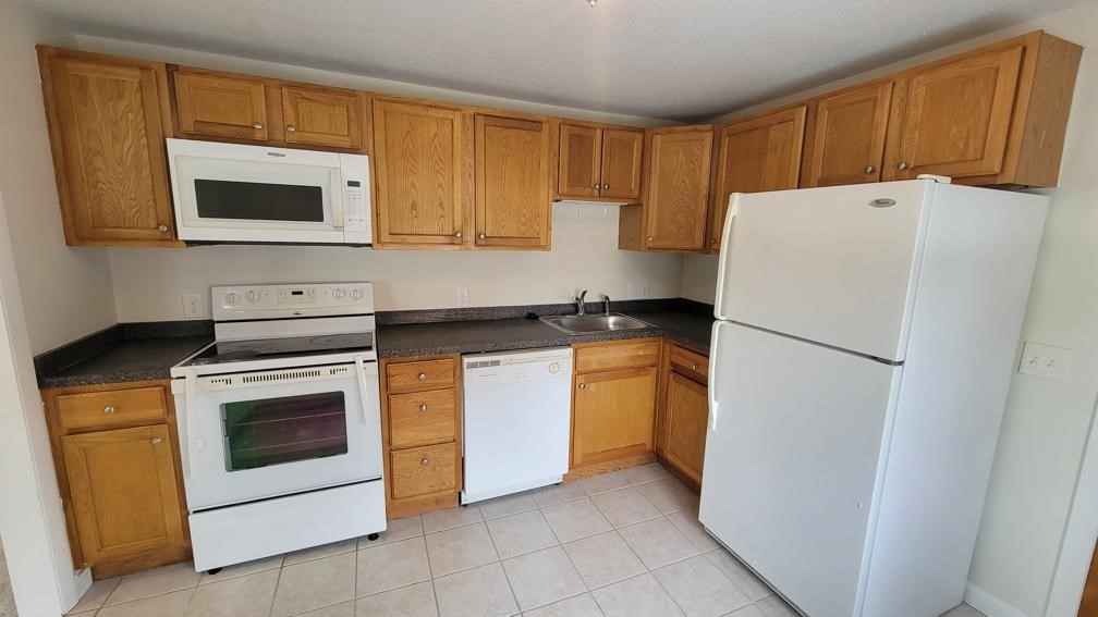 6 Whitman Road, Unit 6 Waltham, MA 02453 - Photo 5 of 12 a kitchen with a refrigerator sink and microwave
