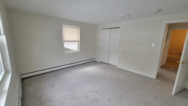 an empty room with windows and closet
