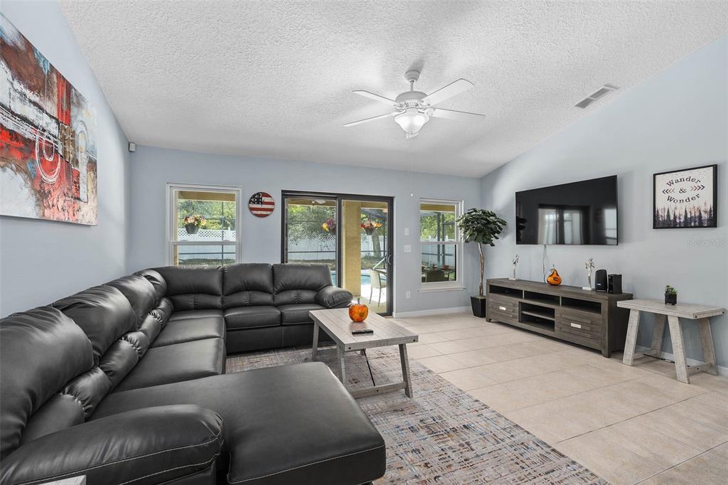 1030 Coventry Road Davenport, FL 33897 - Photo 11 of 48 a living room with furniture and a flat screen tv