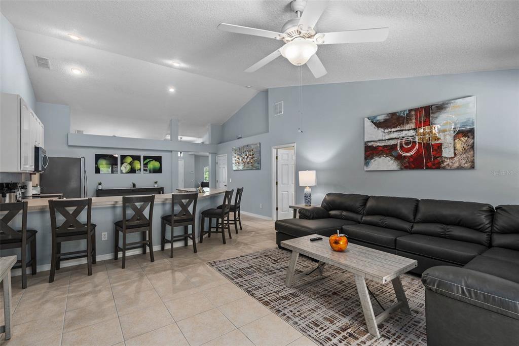 1030 Coventry Road Davenport, FL 33897 - Photo 12 of 48 a living room with furniture a table and kitchen view