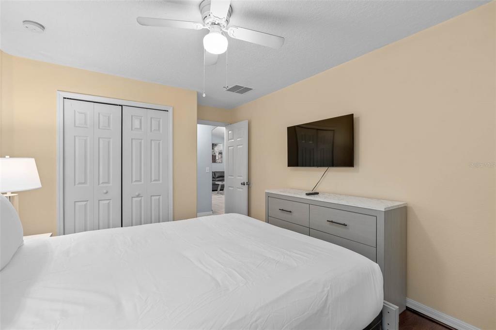 1030 Coventry Road Davenport, FL 33897 - Photo 23 of 48 a bedroom with a bed and a flat tv screen on dresser