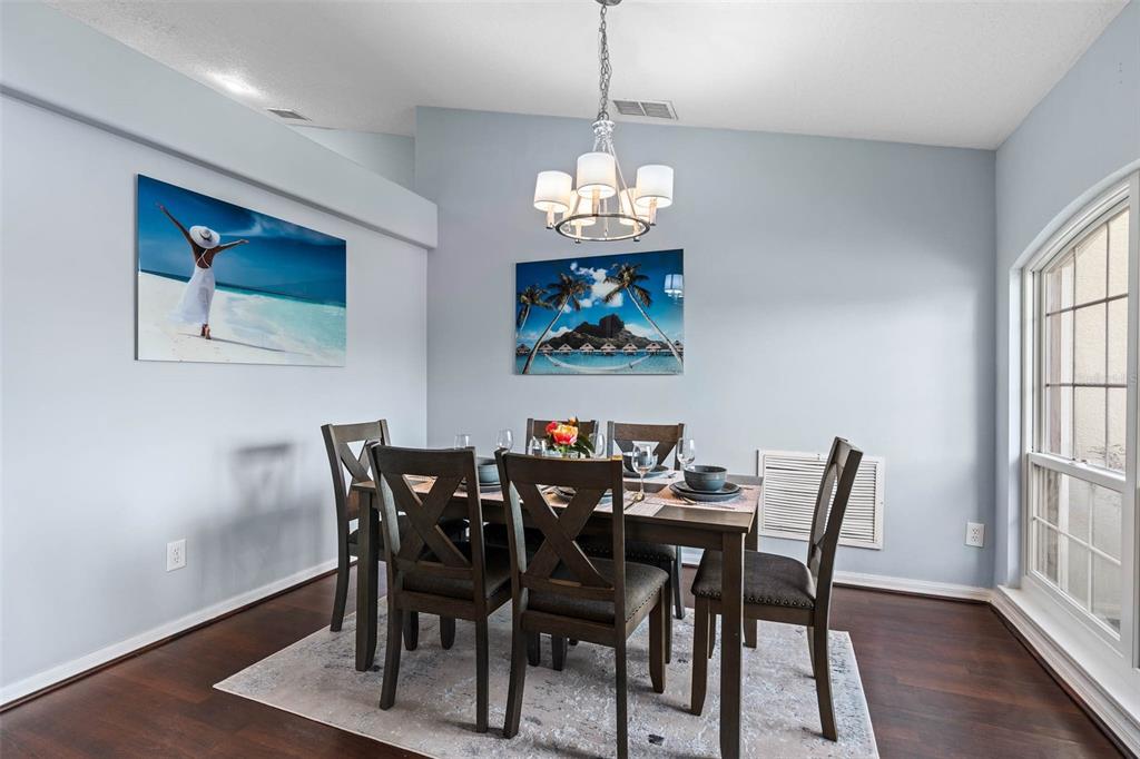 1030 Coventry Road Davenport, FL 33897 - Photo 4 of 48 a view of a dining room with furniture a chandelier and wooden floor