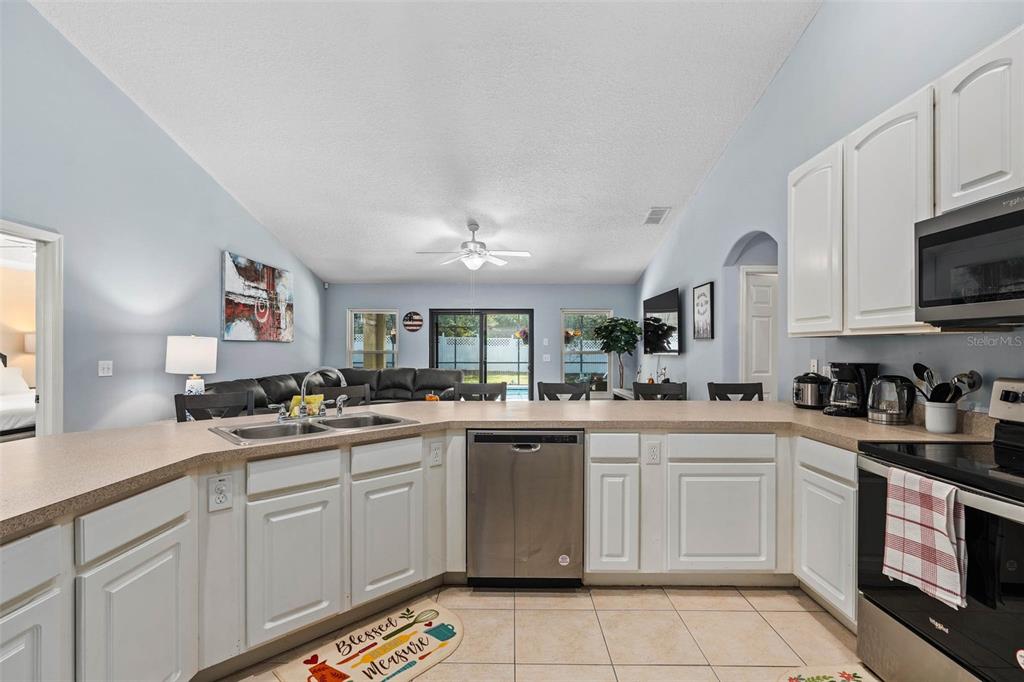 1030 Coventry Road Davenport, FL 33897 - Photo 8 of 48 a kitchen with a sink stove and cabinets