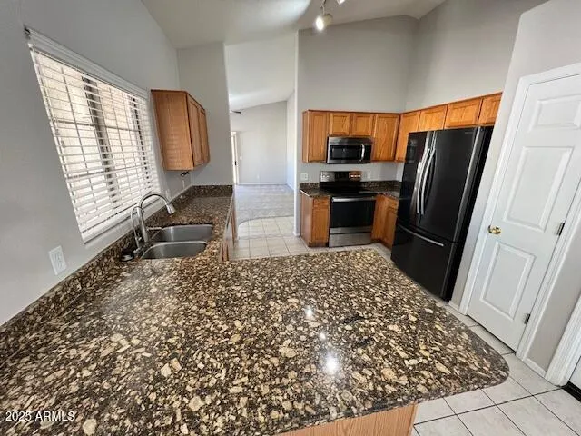 a kitchen with granite countertop a refrigerator and a sink
