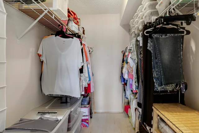 a view of walk in closet with clothes and shoes