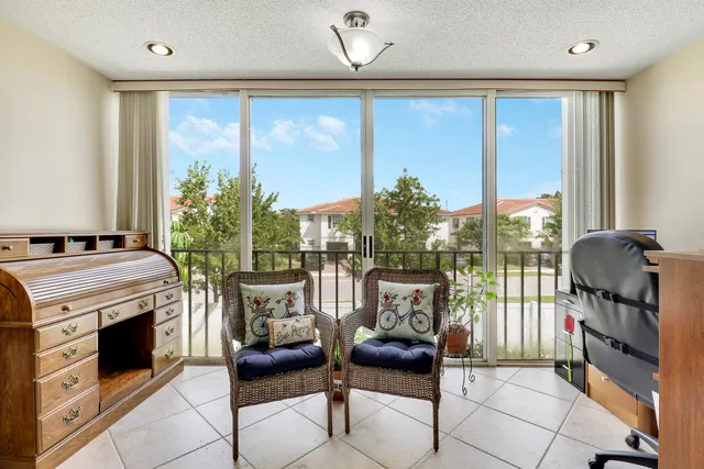 a living room with furniture a flat screen tv and a floor to ceiling window