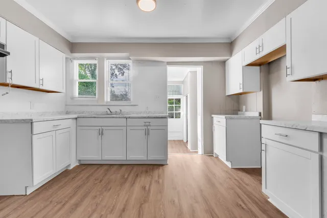 a kitchen with a sink window and cabinets