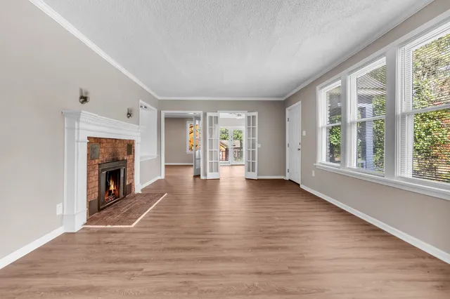 wooden floor fireplace and windows in an empty room