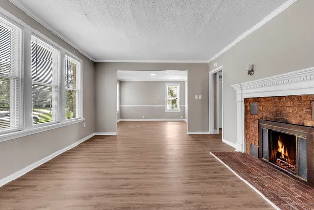 a view of an empty room with window and fire place