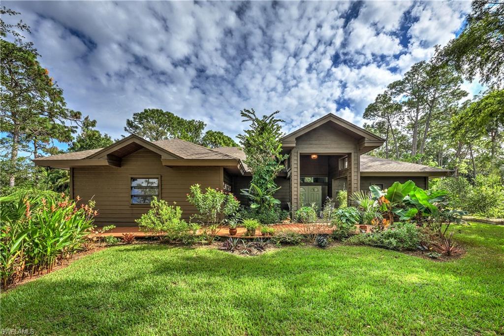 a front view of a house with a yard and potted plants