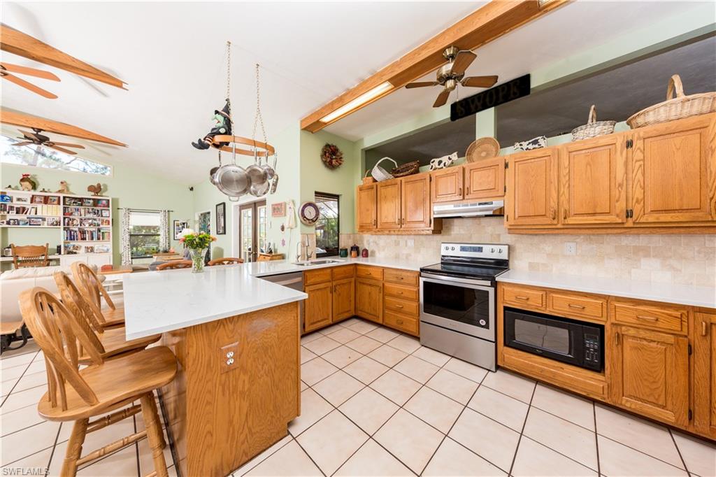 632 Hickory Road Naples, FL 34108 - Photo 4 of 20 a kitchen with stainless steel appliances kitchen island granite countertop a sink and cabinets