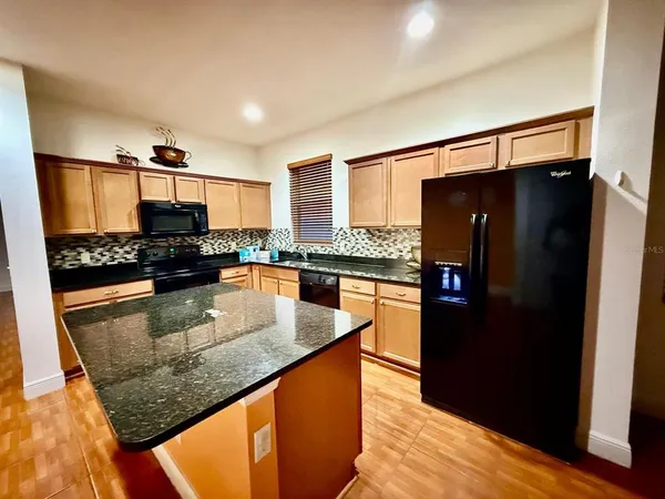 a kitchen with stainless steel appliances granite countertop a refrigerator stove and oven