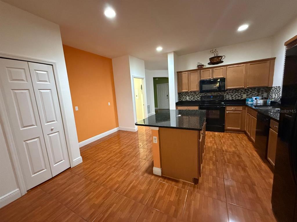 2716 Randal Way Kissimmee, FL 34743 - Photo 4 of 15 a kitchen with stainless steel appliances granite countertop a stove top oven a sink and a refrigerator