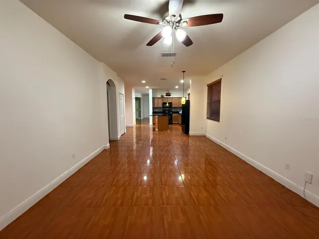 a view of a livingroom with a ceiling fan and wooden floor