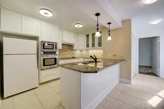 a kitchen with stainless steel appliances granite countertop a sink and a refrigerator