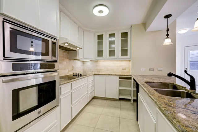 a kitchen with stainless steel appliances granite countertop a sink and stove top oven