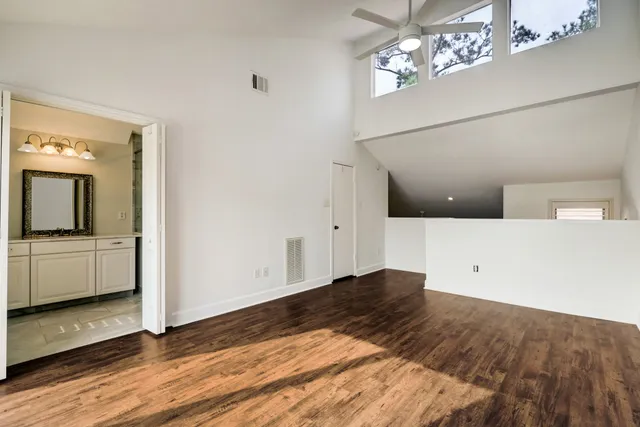 a view of a hallway with wooden floor and staircase