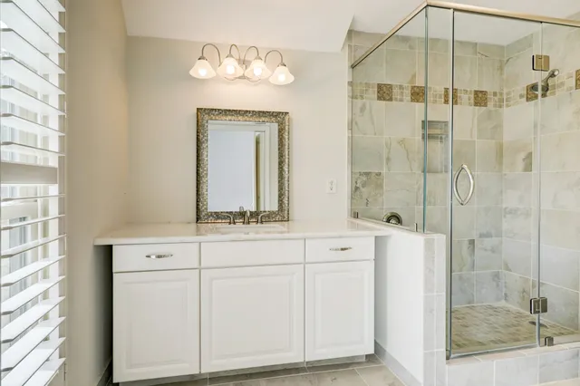 a bathroom with a sink a mirror and shower