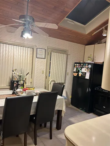 a dining room with a table chairs and a kitchen