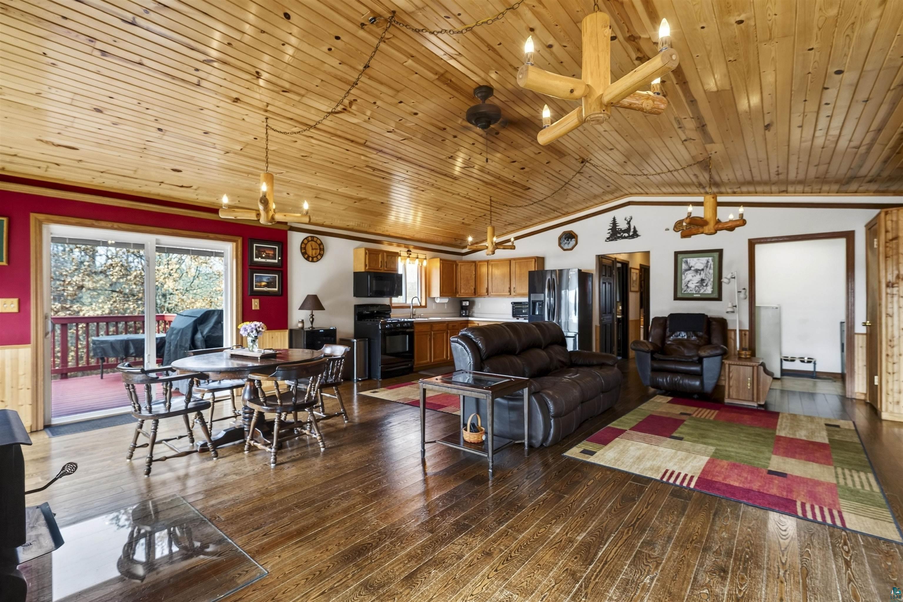 11702 East Mail Road Gordon, WI 54838 - Photo 31 of 49 Living room with dark wood finished floors, a vaulted wooden ceiling, and a chandelier