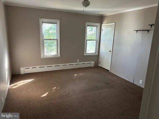 an empty room with a windows and a ceiling fan