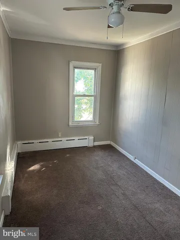 an empty room with a windows and ceiling fan