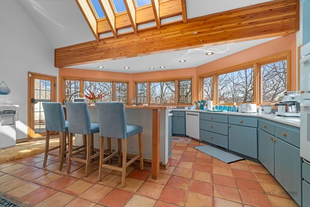 a view of a dining room with furniture one side kitchen view and wooden floor