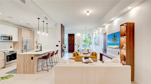 a living room with stainless steel appliances kitchen island granite countertop furniture and a kitchen view
