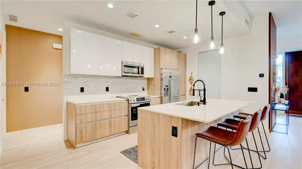 a view of kitchen with sink refrigerator and dining table
