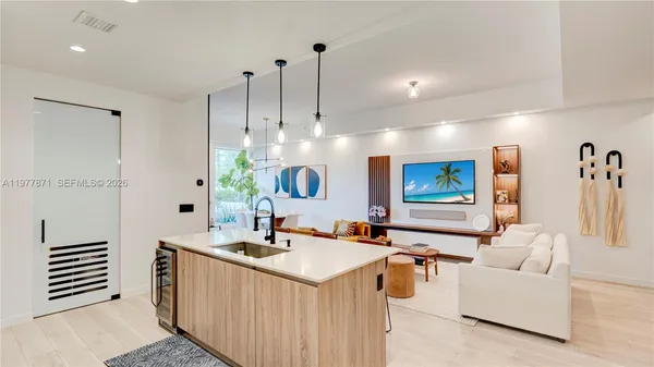 a kitchen with a sink and living room view