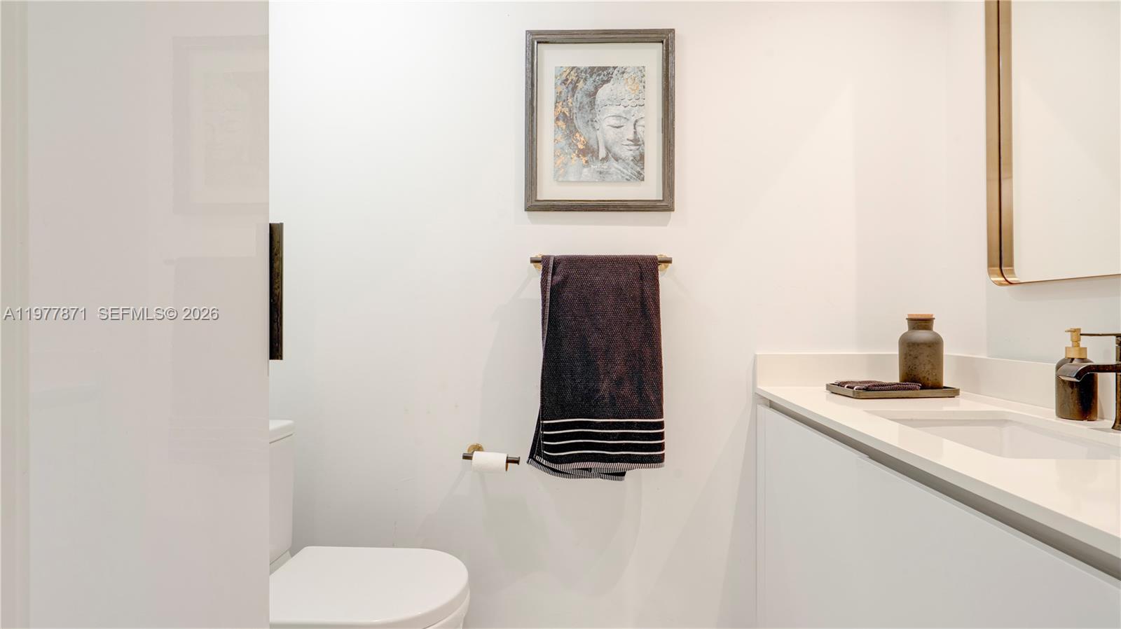 545 Southwest 11th Street, Unit 105 Miami, FL 33129 - Photo 24 of 43 a bathroom with a toilet sink and mirror