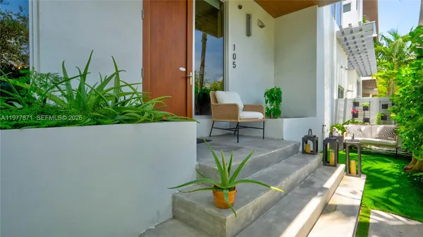 a view of a balcony with chairs and a potted plant
