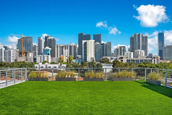 a view of a city with tall buildings and a big yard