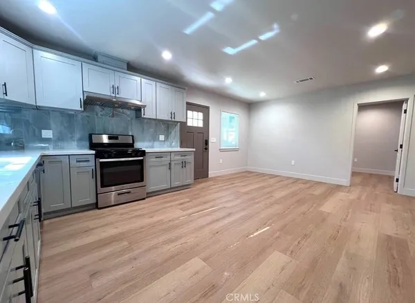 a kitchen with stainless steel appliances granite countertop a stove a sink and a refrigerator
