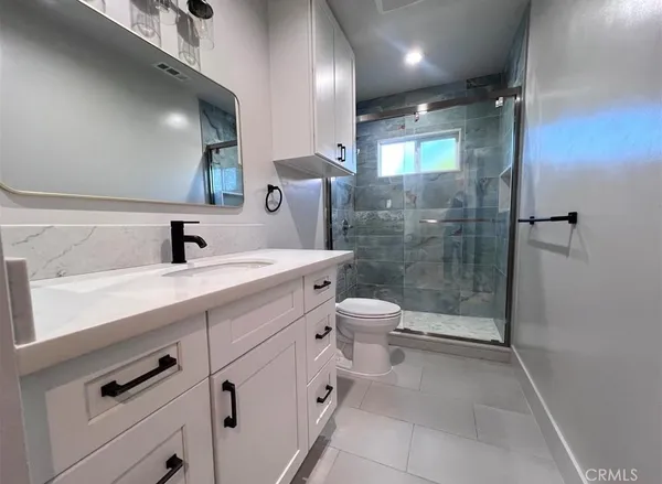 a bathroom with a double vanity sink toilet and shower