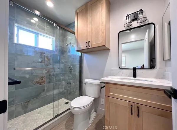 a bathroom with a sink a toilet and shower