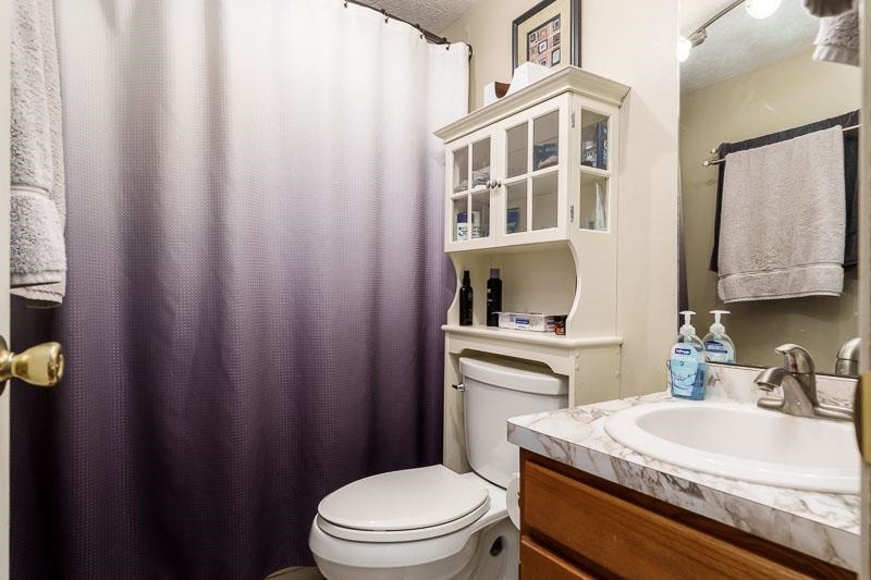 5280 Sunbird Drive Loves Park, IL 61111 - Photo 32 of 42 a bathroom with a sink a toilet and shower curtain