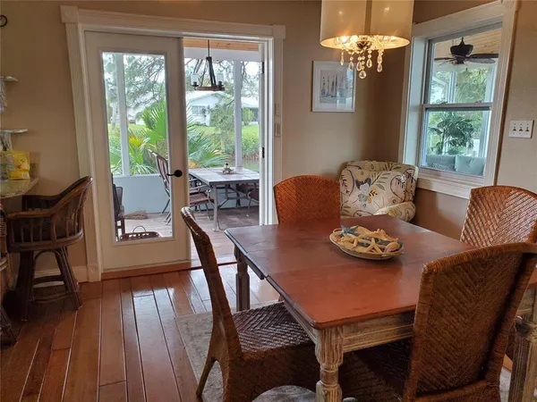 a view of a dining room with furniture a chandelier and wooden floor