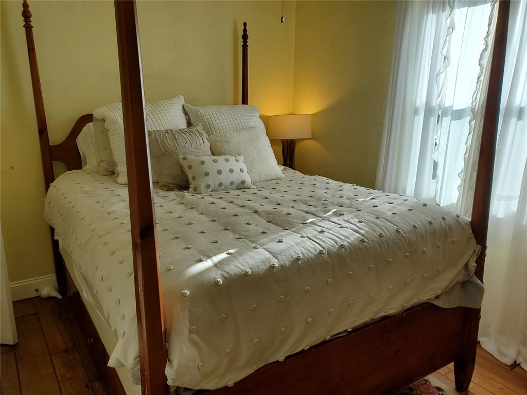 227 Lychee Road Nokomis, FL 34275 - Photo 6 of 36 a bedroom with a bed and wooden floor
