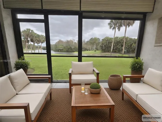 a living room with patio furniture and a garden